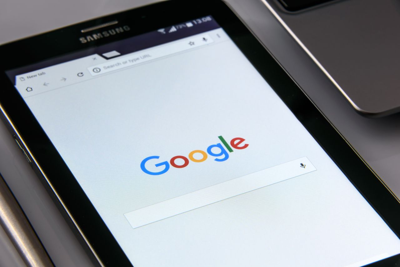 services-04 Close-up of a tablet displaying Googles search screen, emphasizing technology and internet browsing.